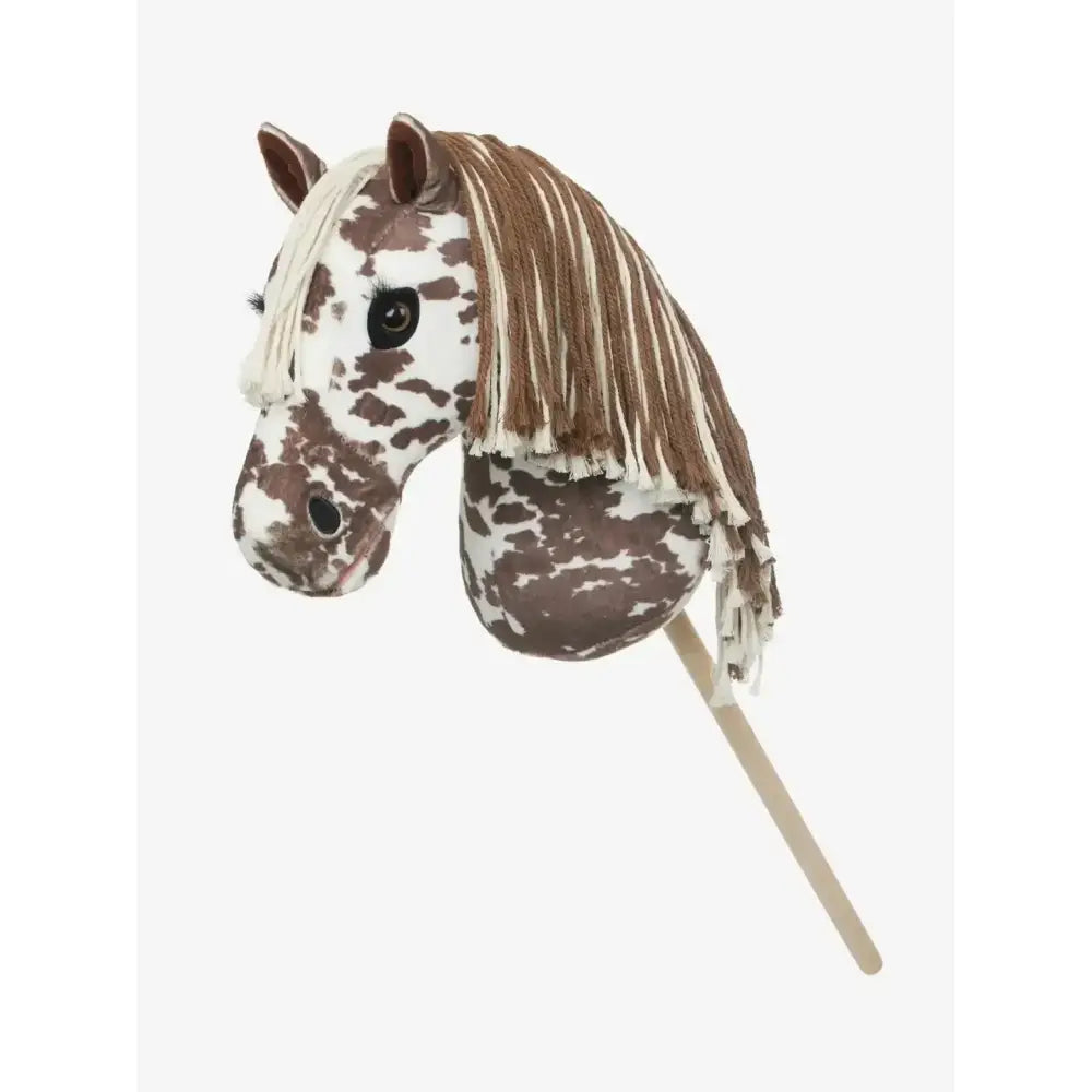 A plush brown and white spotted lemieux hobby horse montana head with a fringed mane on a wooden stick
