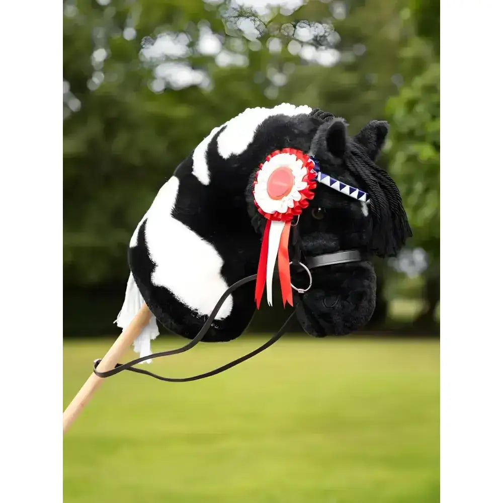 Black and white plush lemieux hobby horse with a red white and blue hobby horse rosette pinned to its head