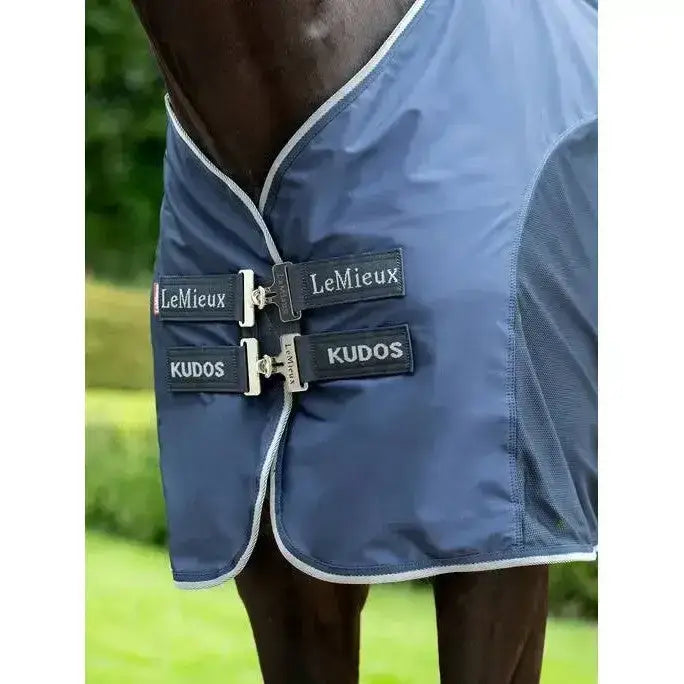 Navy blue lemieux kudos hybrid horse blanket with white trim and silver buckles designed as kudos hybrid cooler navy