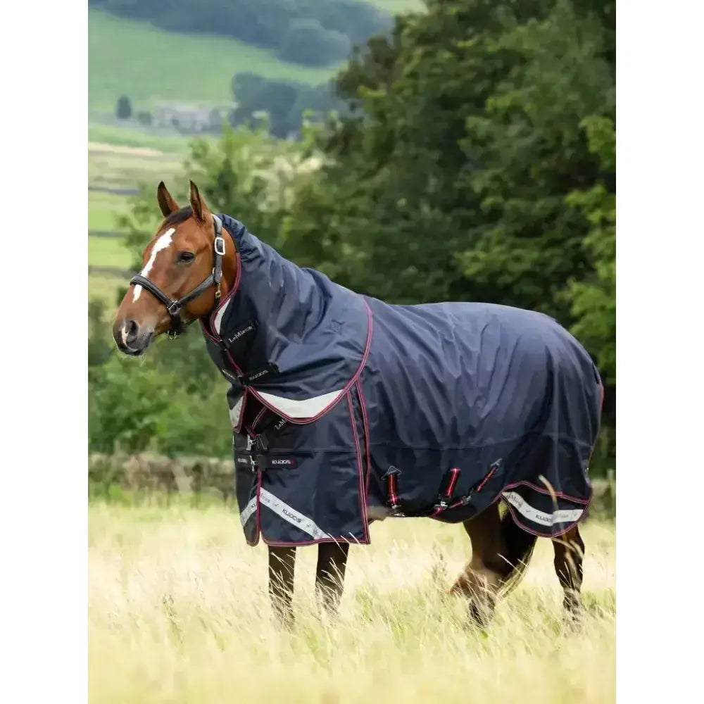 Navy blue lemieux kudos thermo layer turnout rug with red white trim adjustable straps and reflective panels for visibility