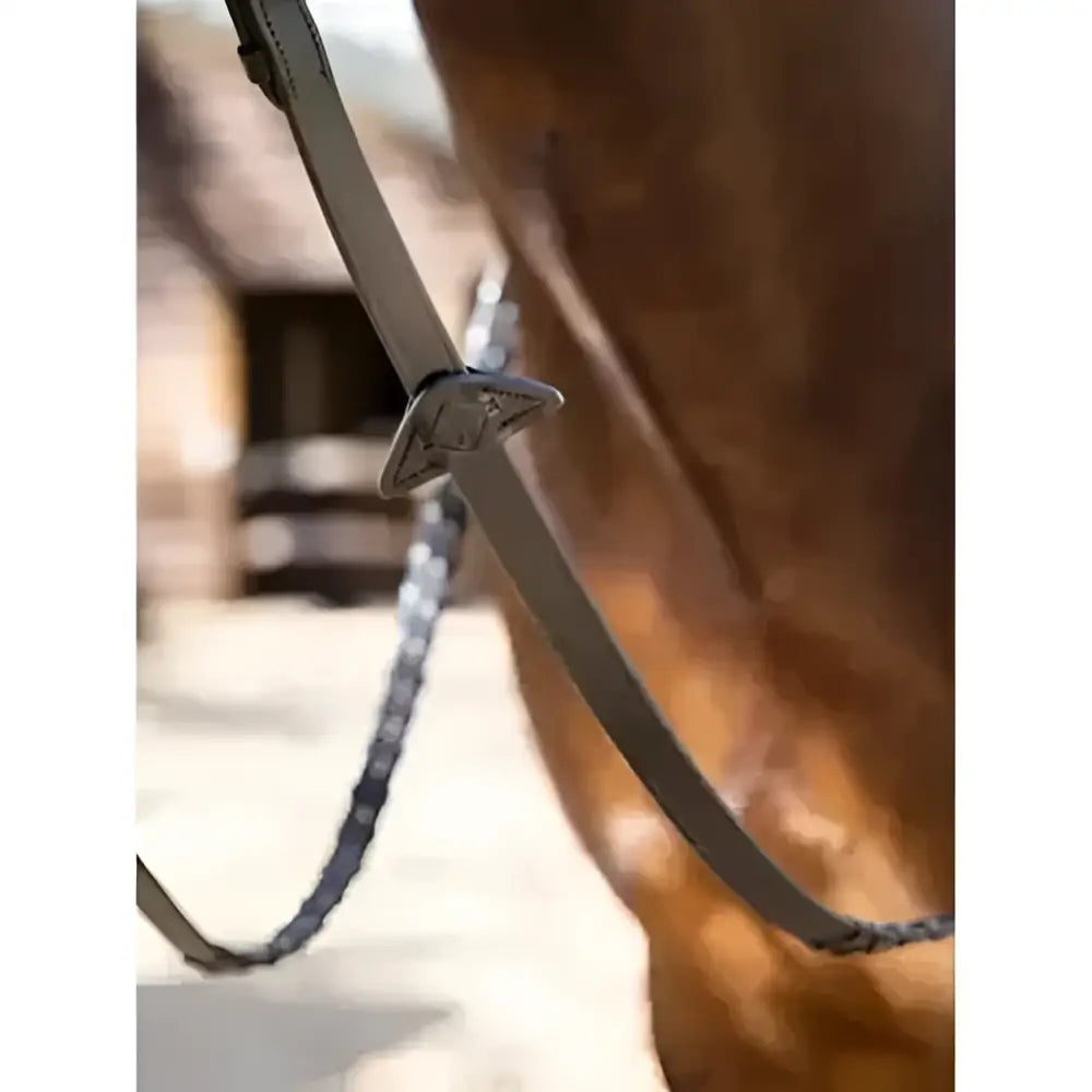 Silver-toned metal buckle on dark brown leather strap of lemieux leather laced classic leather reins