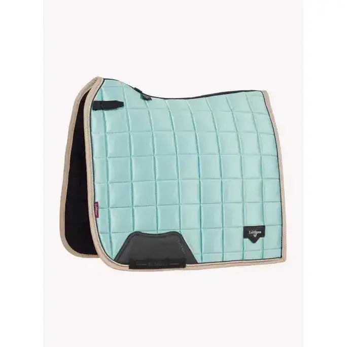 Light blue quilted lemieux loire classic dressage square aqua saddle pad with beige trim and black accents and logo patch
