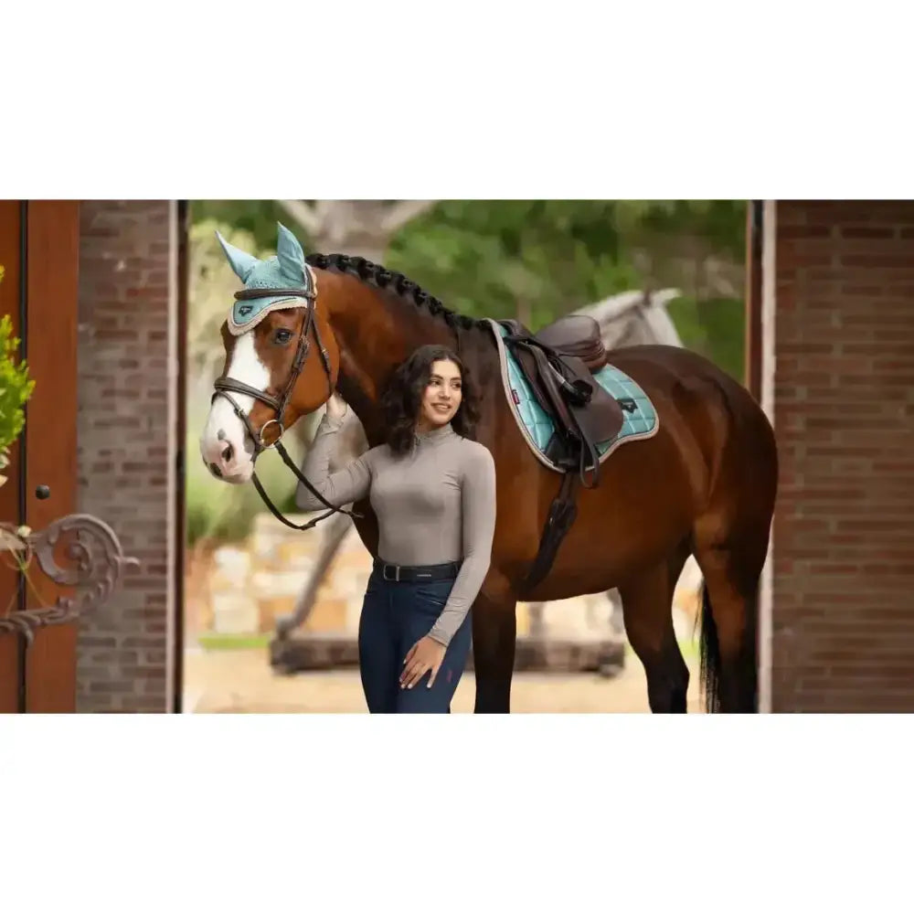 The lemieux loire classic gp square aqua ear cover is light blue with a soft texture and embroidered logo on the horse