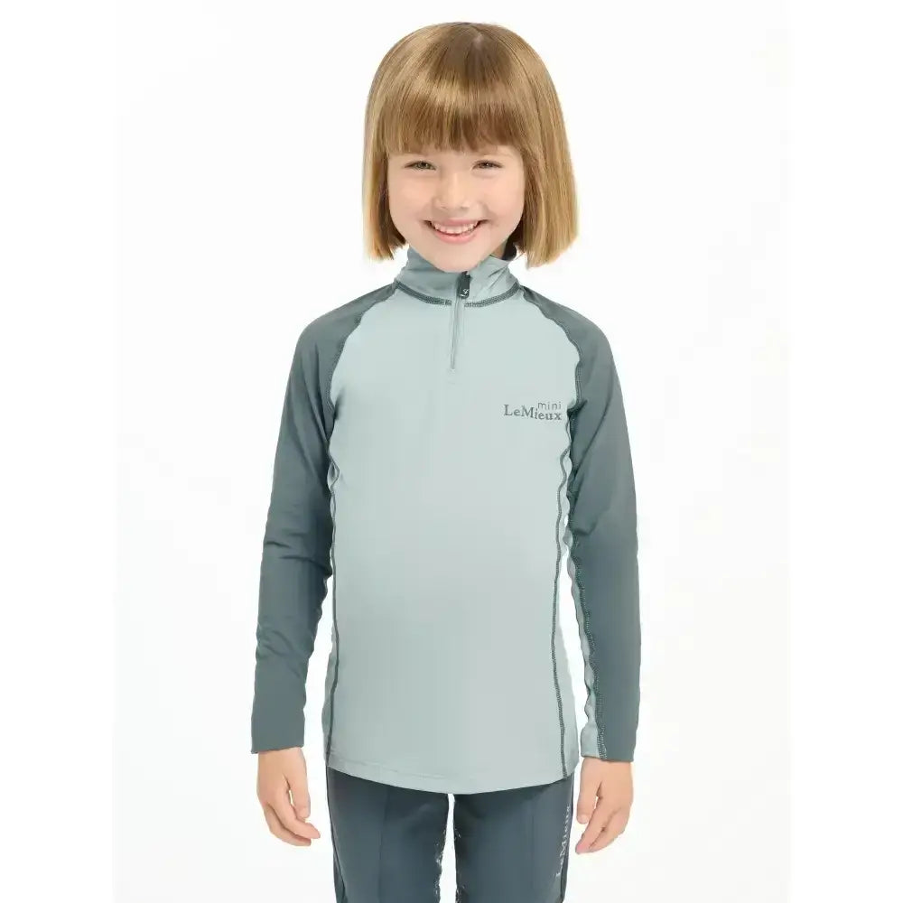 Light blue and dark gray lemieux mini base layer glacier top with quarter-zip and logo for mini riders running