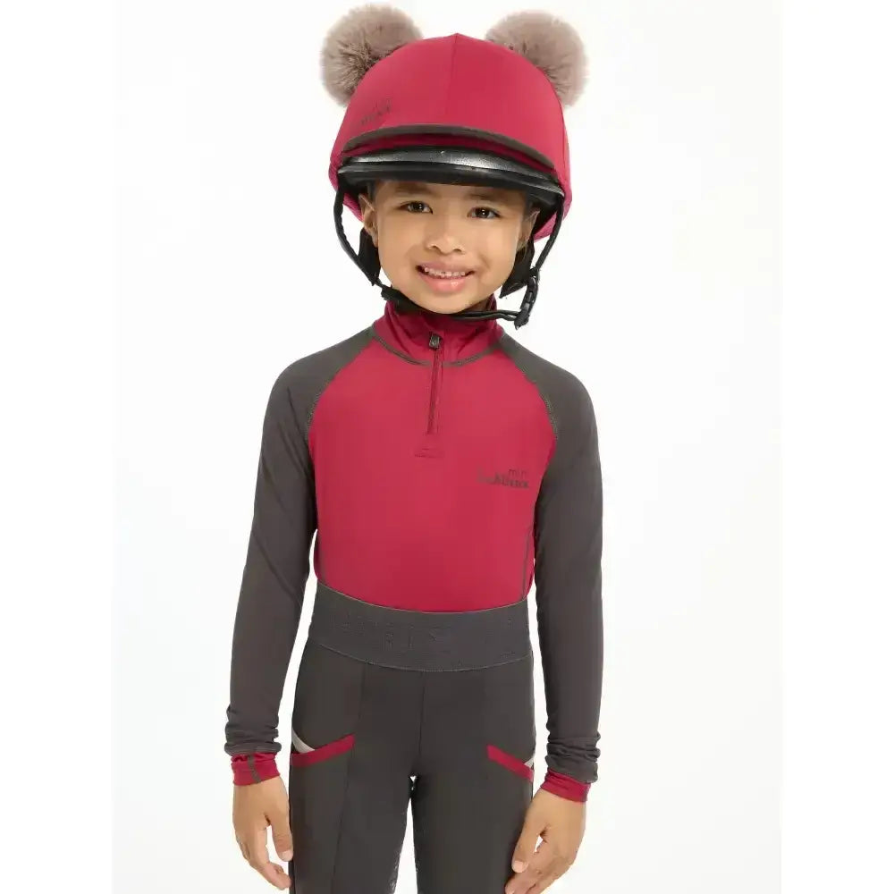 Red and gray equestrian outfit with lemieux mini double pom hat silk ember featuring fluffy double pom hat details