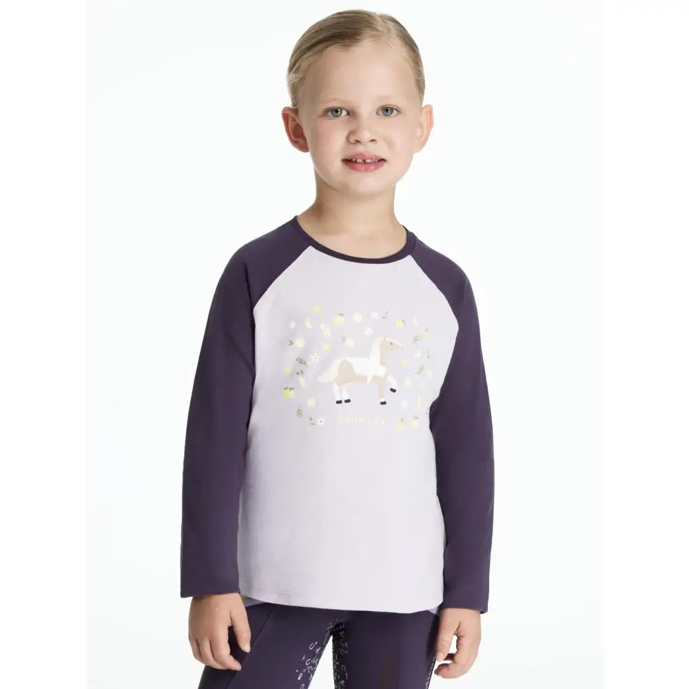 A child wearing a lemieux mini jamie lemon long sleeve top with navy sleeves, white body, and glittery unicorn design