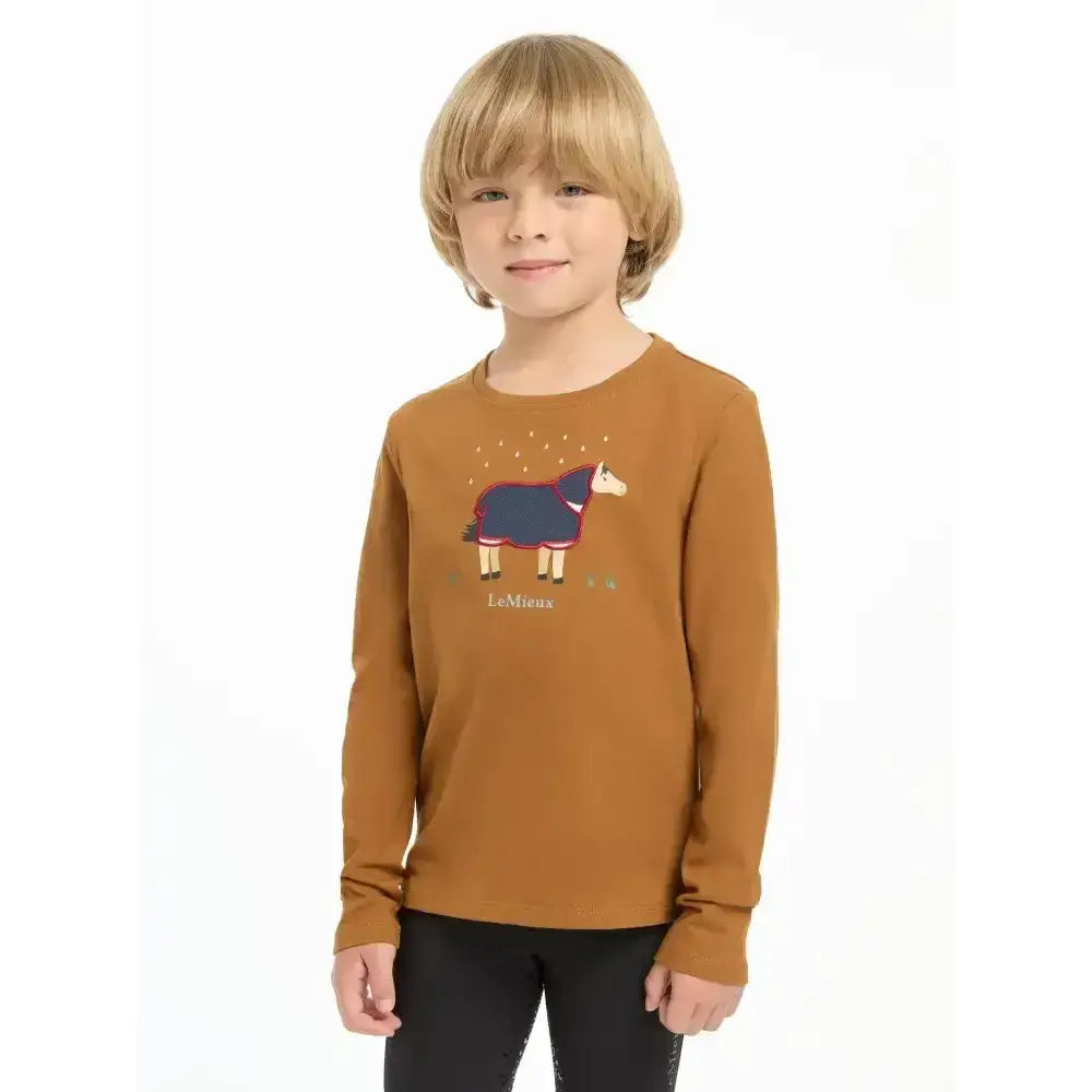 A child wearing a rust-colored lemieux mini jessie classic relaxed-fit long-sleeved top in nep cluster-textured fabric