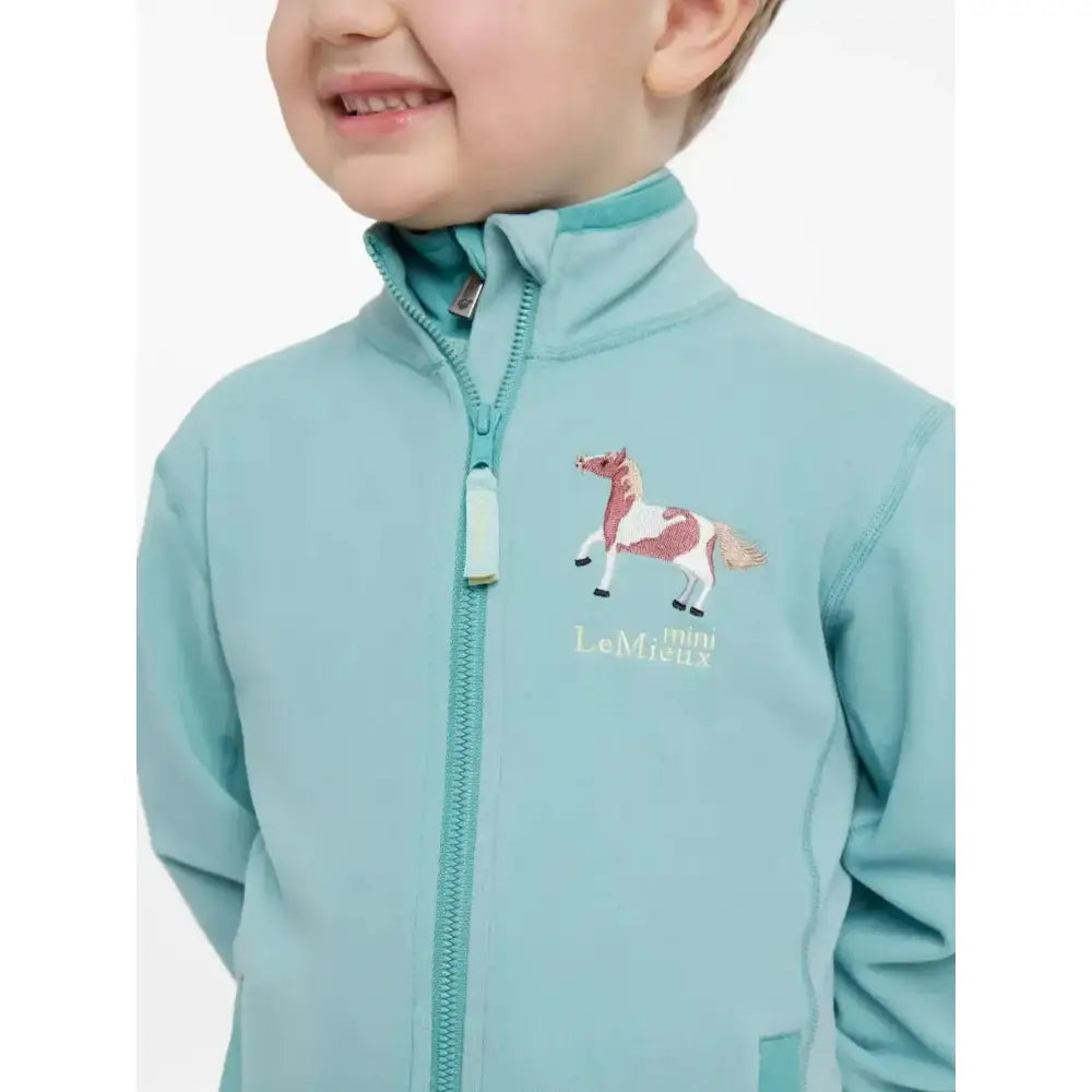 Light teal lemieux mini mari micro fleece aqua jacket with embroidered horse design on chest in pink and white