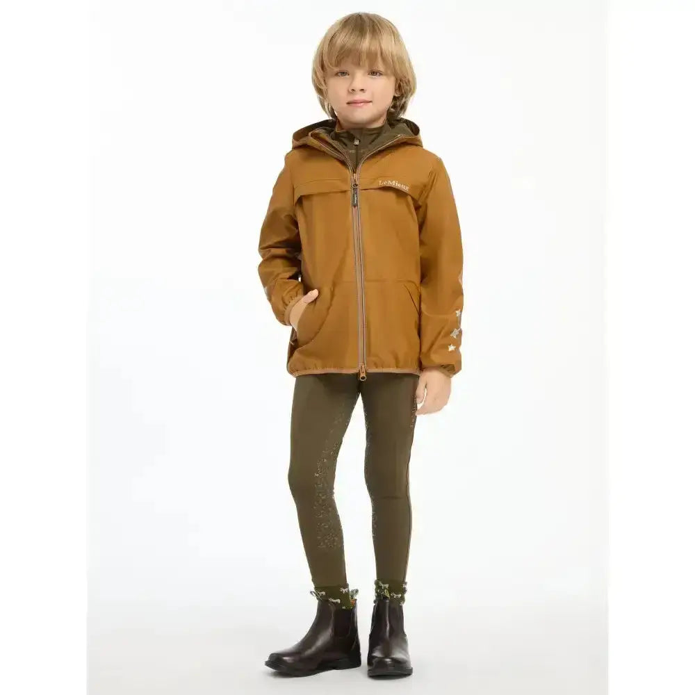 A child wearing a tan lemieux mini milo winter jacket with hood zipper front and star embroidery on sleeves