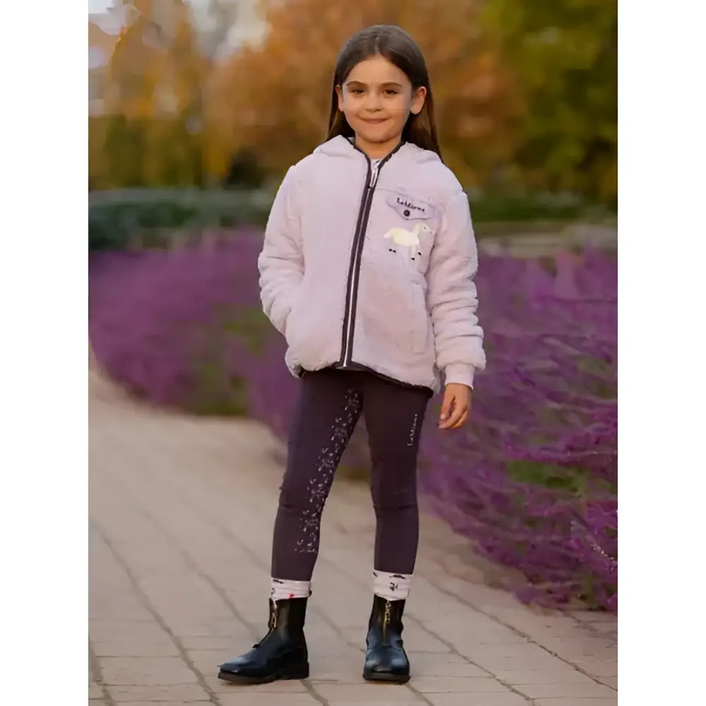 A child wearing a light purple lemieux mini pull puffer jacket paired with dark sparkly mini riders pull ons juniper leggings