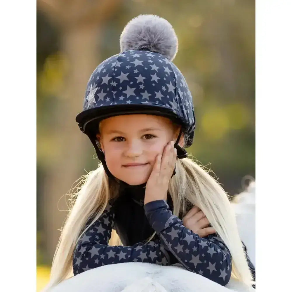 Navy blue lemieux mini reflective equestrian helmet with star pattern and gray faux fur pom hat silk on top