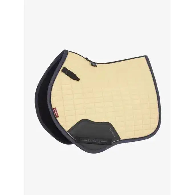 Cream-colored lemieux mini suede close contact square mimosa saddle pad with black trim and quilted texture and logo