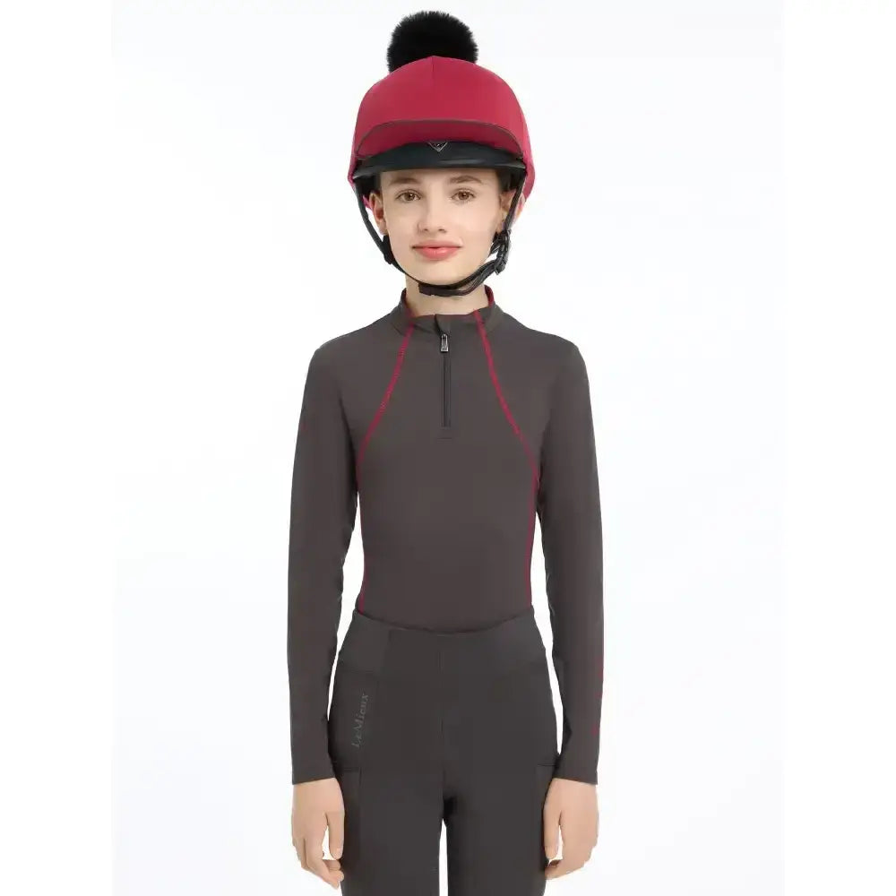 A maroon lemieux pippa hat with black faux-fur pom-pom in silk ember perfect for equestrian use