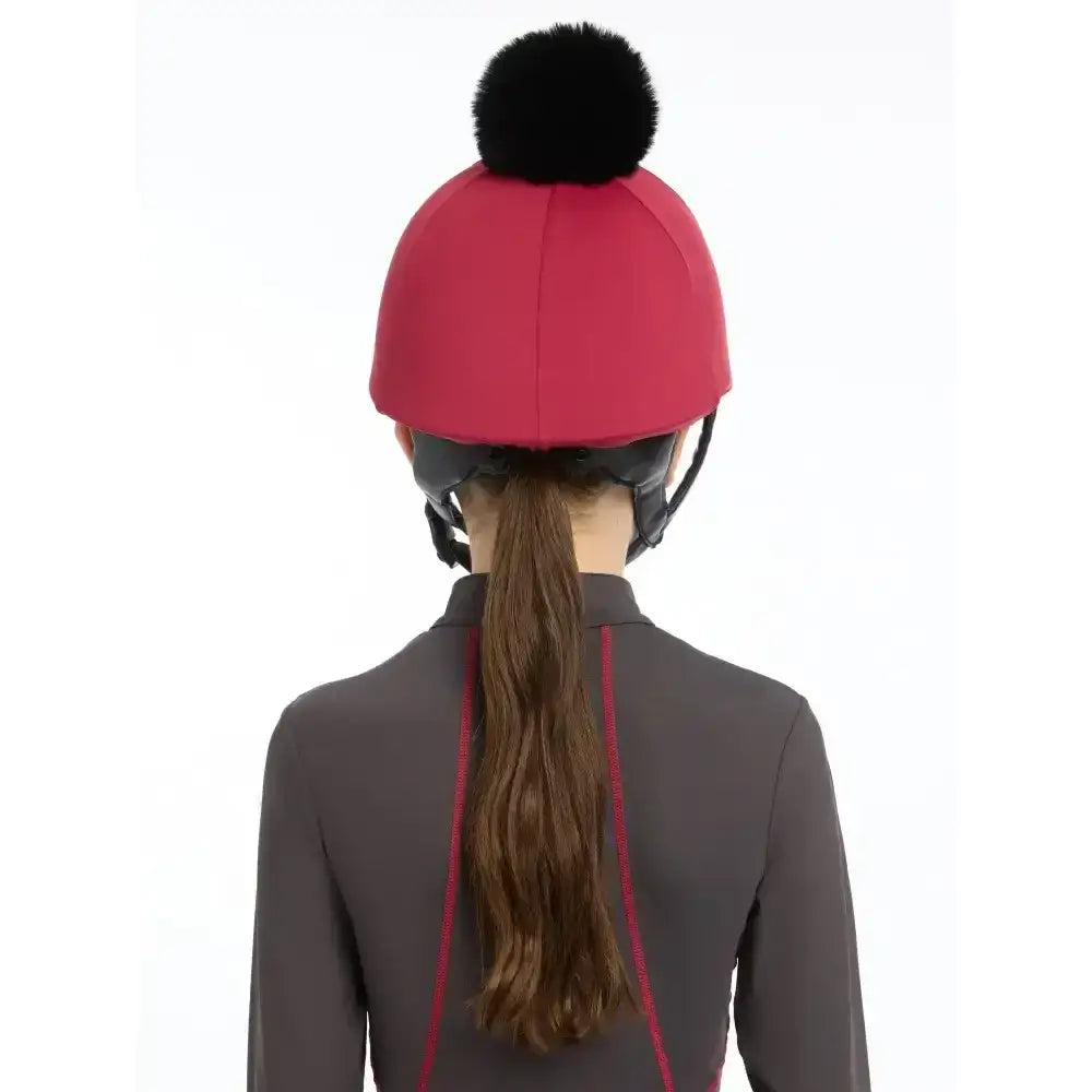 Red lemieux pippa hat silk ember helmet with a black fluffy pom pom perfect for equestrian use