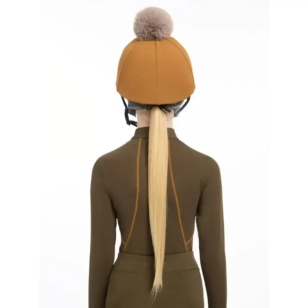 A mustard-yellow lemieux pippa hat silk ginger with a fluffy gray pom-pom perfect for equestrian use