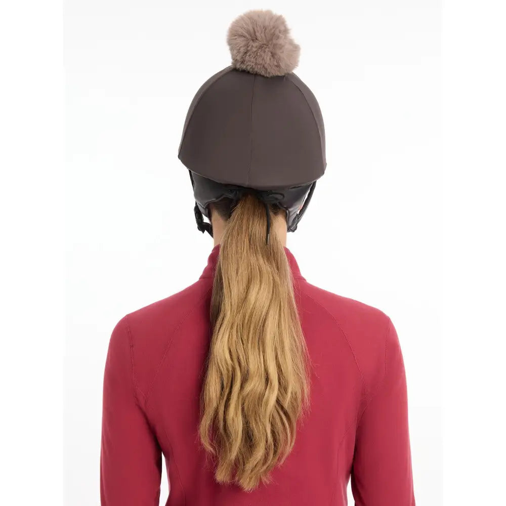 Brown lemieux pom hat silk cinder made equestrian helmet with a fluffy beige pom-pom and silky smooth four-way fabric