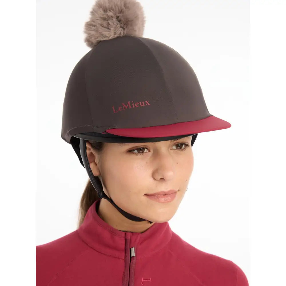 Dark gray lemieux pom hat silk cinder made equestrian helmet with red brim and fluffy beige pom pom on top