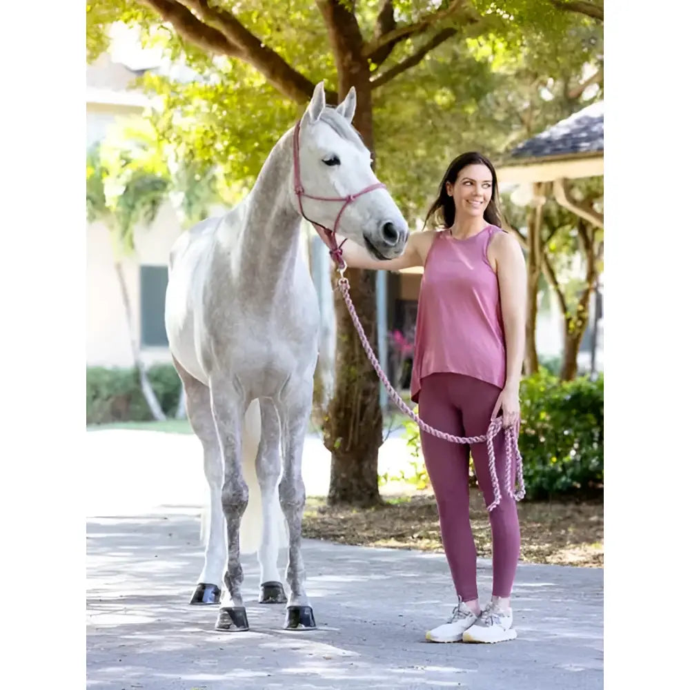 A woman in pink stands beside a gray horse holding a lemieux rope halter blossom lead rope in gray color