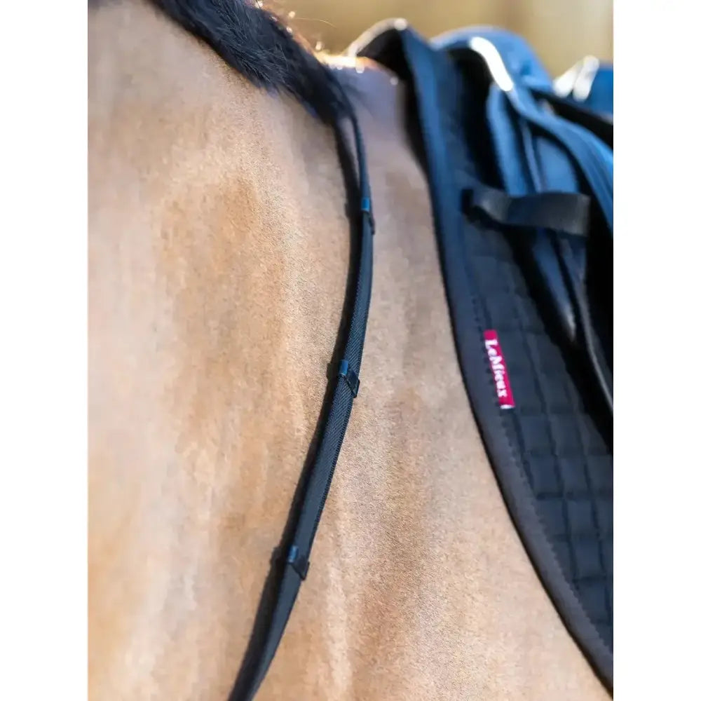 Black padded horse saddle pad with quilted texture and red lemieux rubber label for rubber grip continental reins