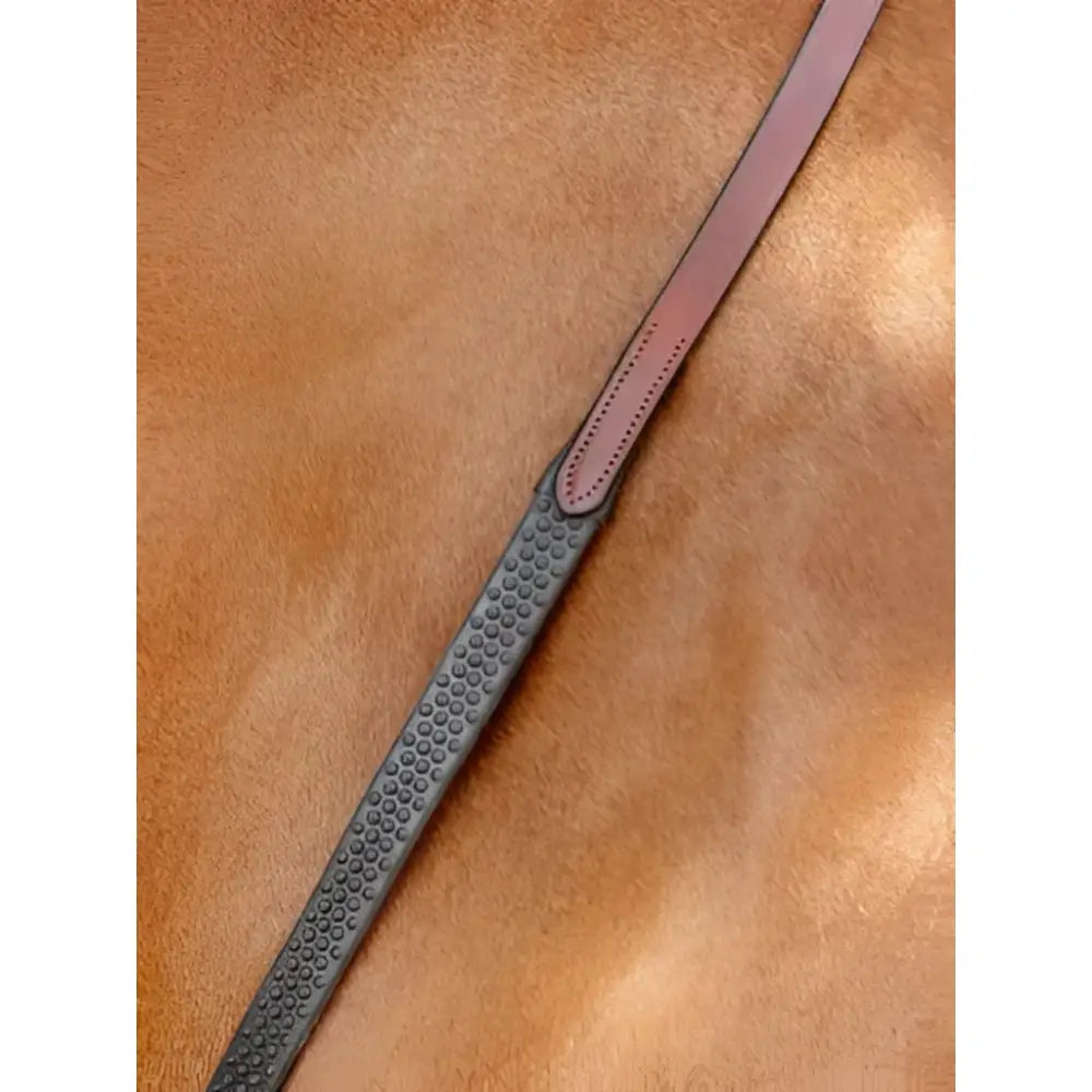 Brown leather riding crop with textured dark gray grip and stitched detailing paired with lemieux soft rubber reins chestnut silver