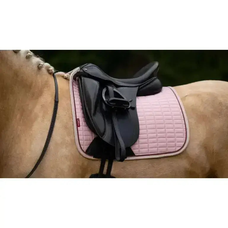 Pink lemieux suede dressage square blossom quilted saddle pad with black edges and subtle grid pattern