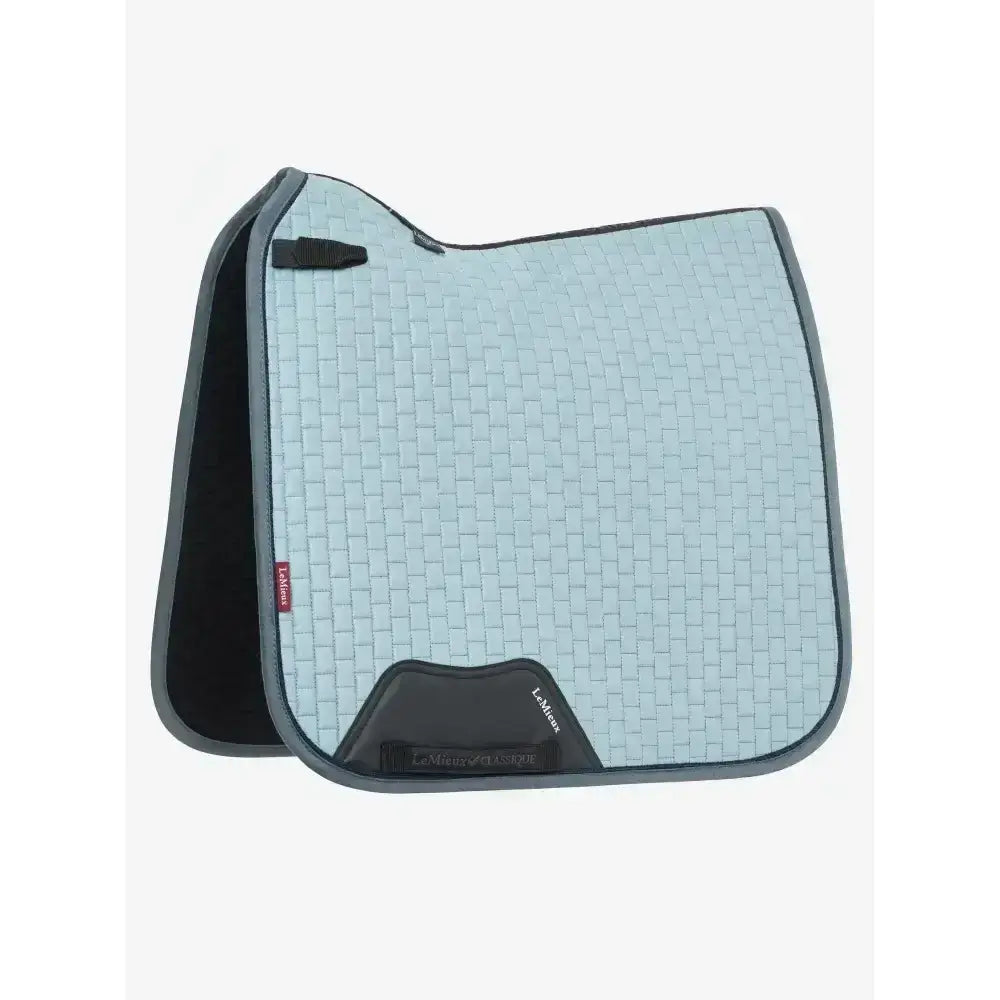 Light blue lemieux suede dressage square glacier saddle pad with black trim and branded label