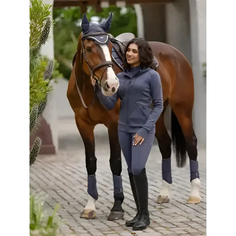 Blue lemieux tabi tech zip through hoodie dusk blue paired with matching leggings and tall boots for riding