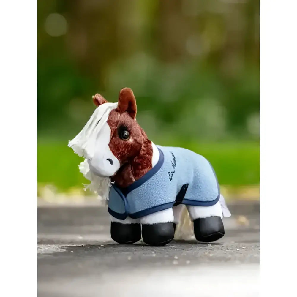 A plush brown and white horse figurine wearing a light blue and navy lemieux tiny pony flash riding coat
