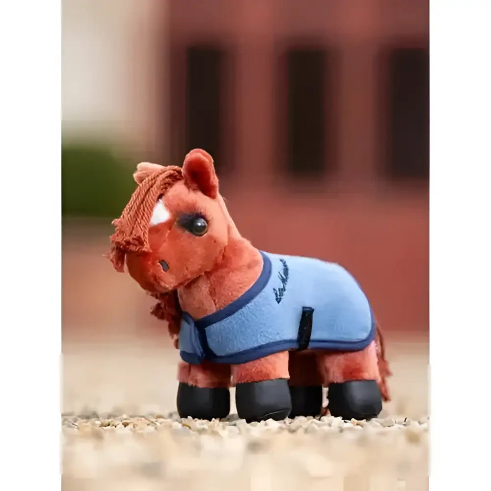 A plush orange lemieux tiny pony thomas figurine wearing a light blue riding blanket with dark blue trim