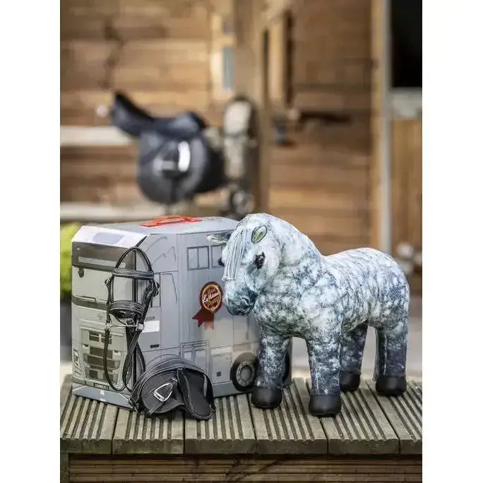 A plush gray and white speckled lemieux toy pony with black hooves stands beside the pony reversible carry case box