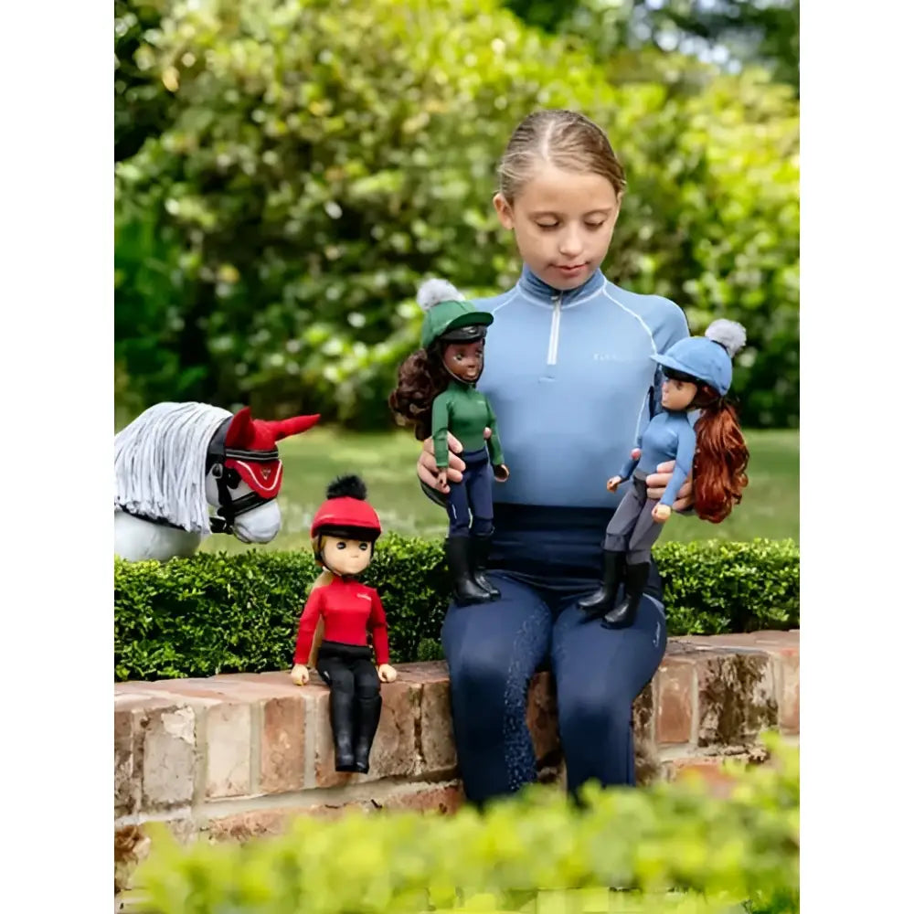 Young girl wearing blue lemieux toy rider chloe outfit suitable for riding a toy pony outdoors