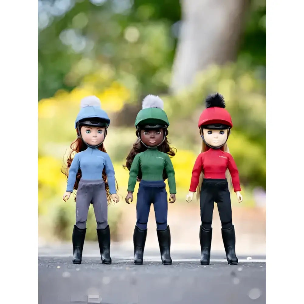 Three lemieux toy rider chloe dolls in blue green and red riding outfits with helmets and black boots on toy ponies