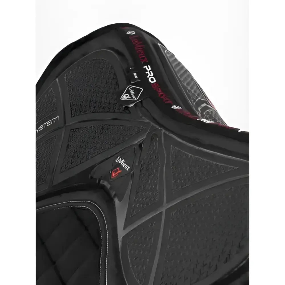 Black silicone dressage square saddle pad with textured quilted surface and red branding accents for saddle stability