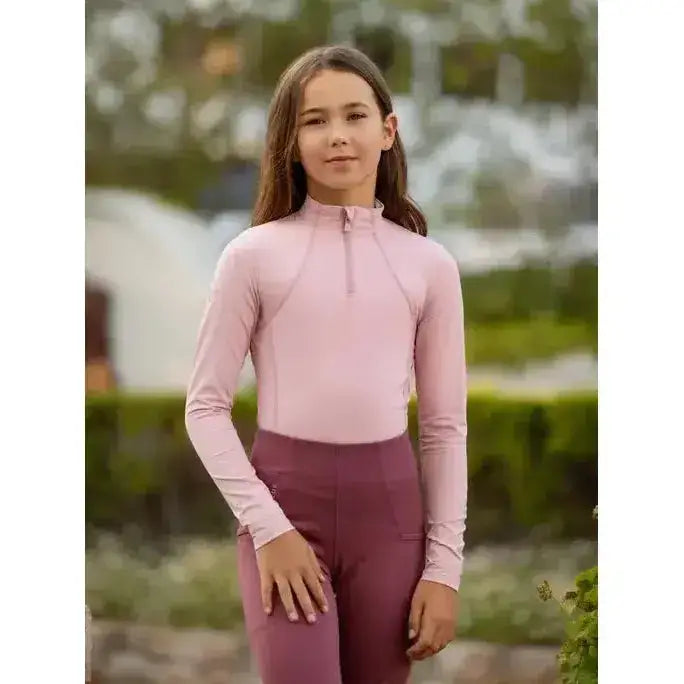 A soft pink lemieux young rider base layer blossom with long sleeves high collar and zip detail perfect for riding