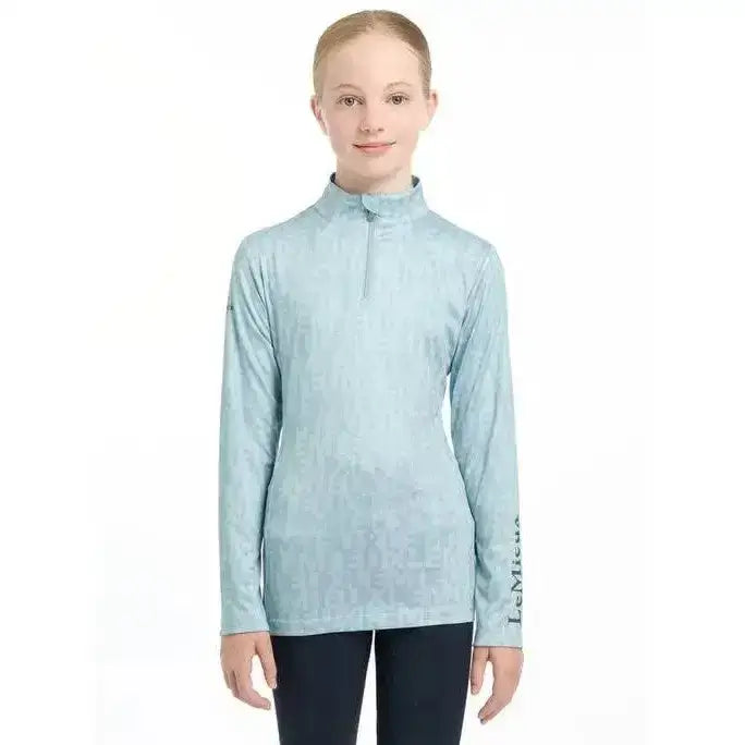 Light blue lemieux young rider casey base layer glacier performance top with long sleeves and quarter zip collar