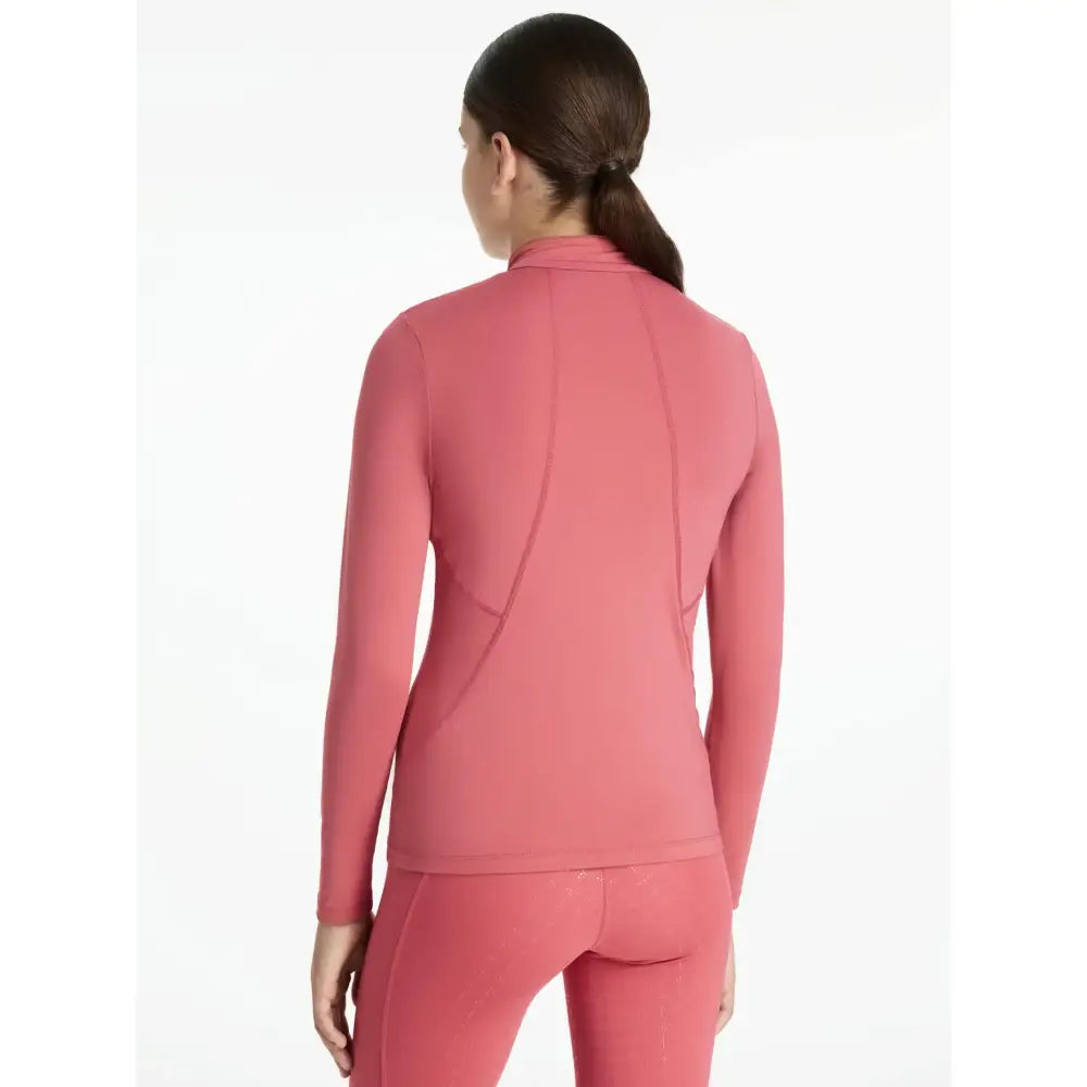 A sleek coral-pink seamless lemieux young rider classique base layer with high collar perfect for cranberry layer warmth