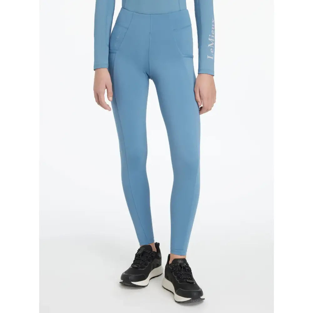 A pair of light blue lemieux young rider classique leggings with high waist and side pockets in ice blue layer