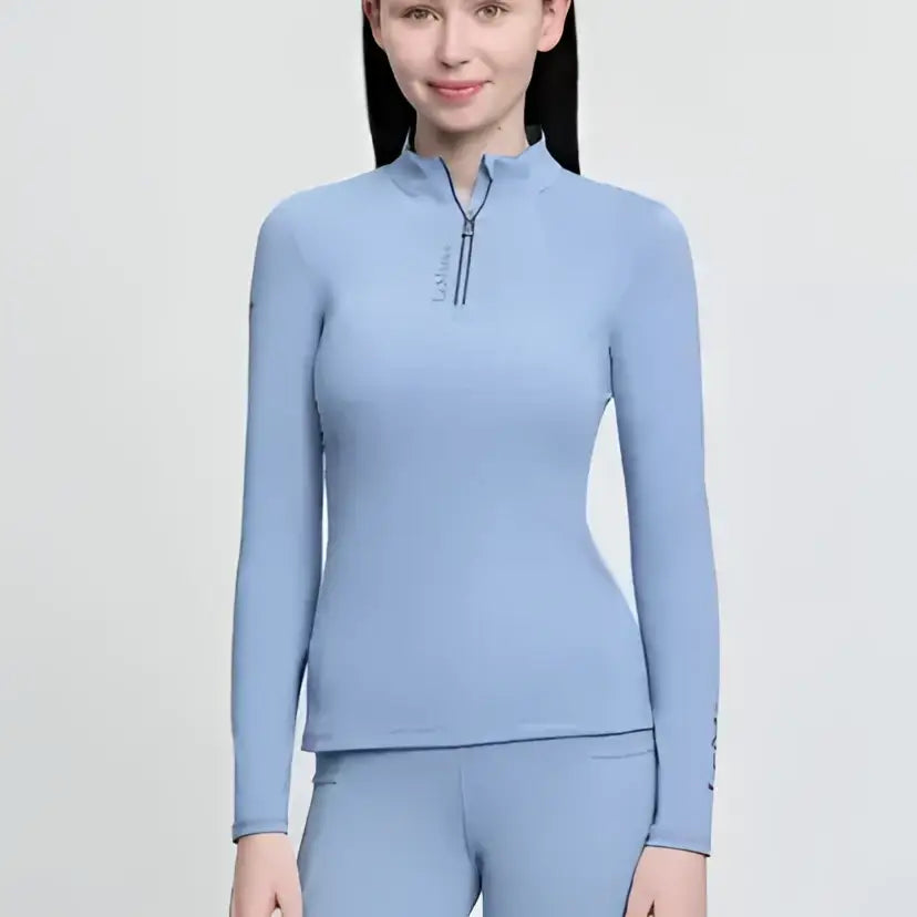 Light blue long-sleeved lemieux young rider classique base layer powder with quarter-zip collar and sleeve branding