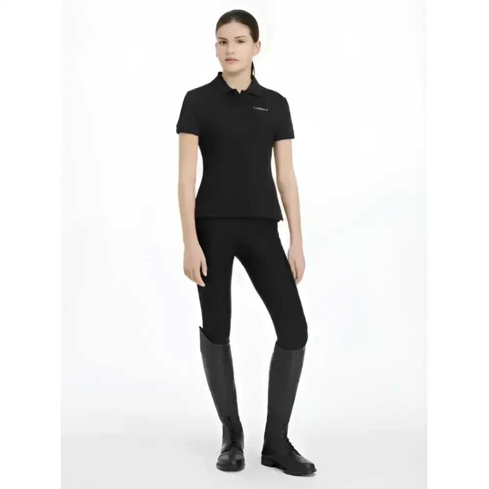 Black short-sleeved lemieux young rider classique polo shirt with subtle embroidered logo on left chest