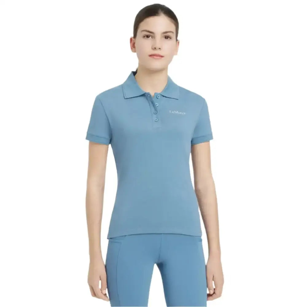 Light blue short-sleeved lemieux young rider classique polo shirt with collar button placket and subtle chest embroidery