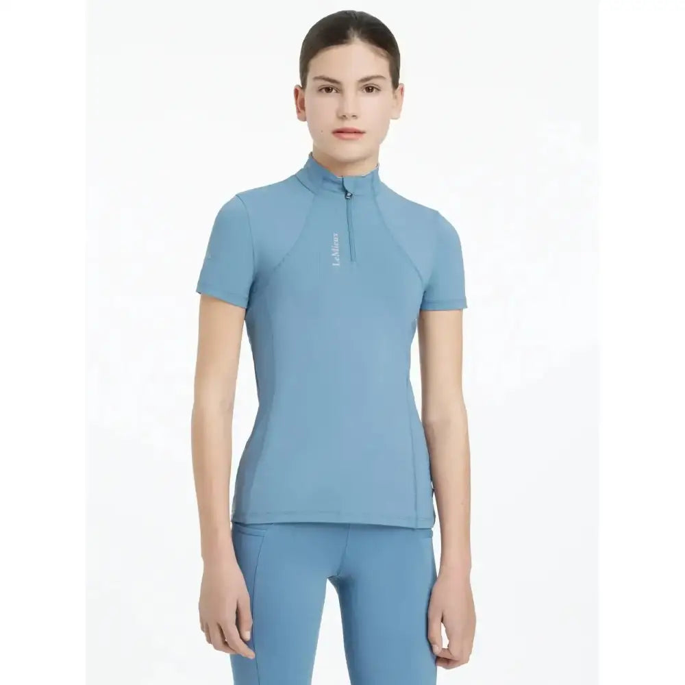 A sleek ice blue lemieux young rider classic short sleeve performance top with a high collar and short sleeves
