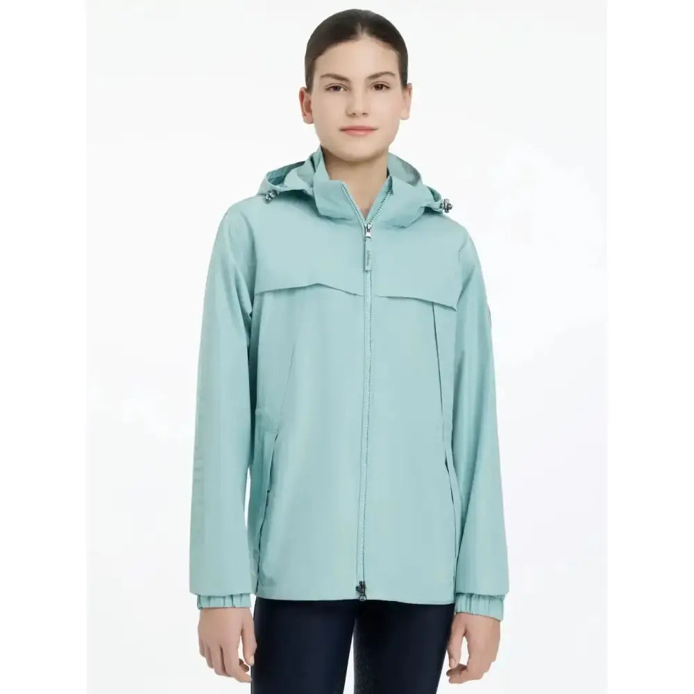 A light mint green lemieux young rider dolcie waterproof jacket with hood and front zipper, lightweight and waterproof