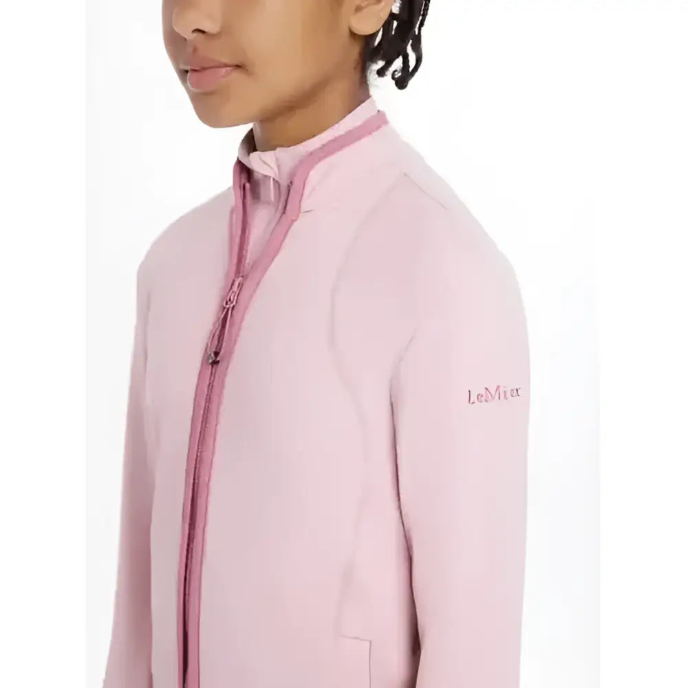 A soft pink lemieux young rider felicity fleece zip-up jacket with matching zipper and subtle sleeve embroidery