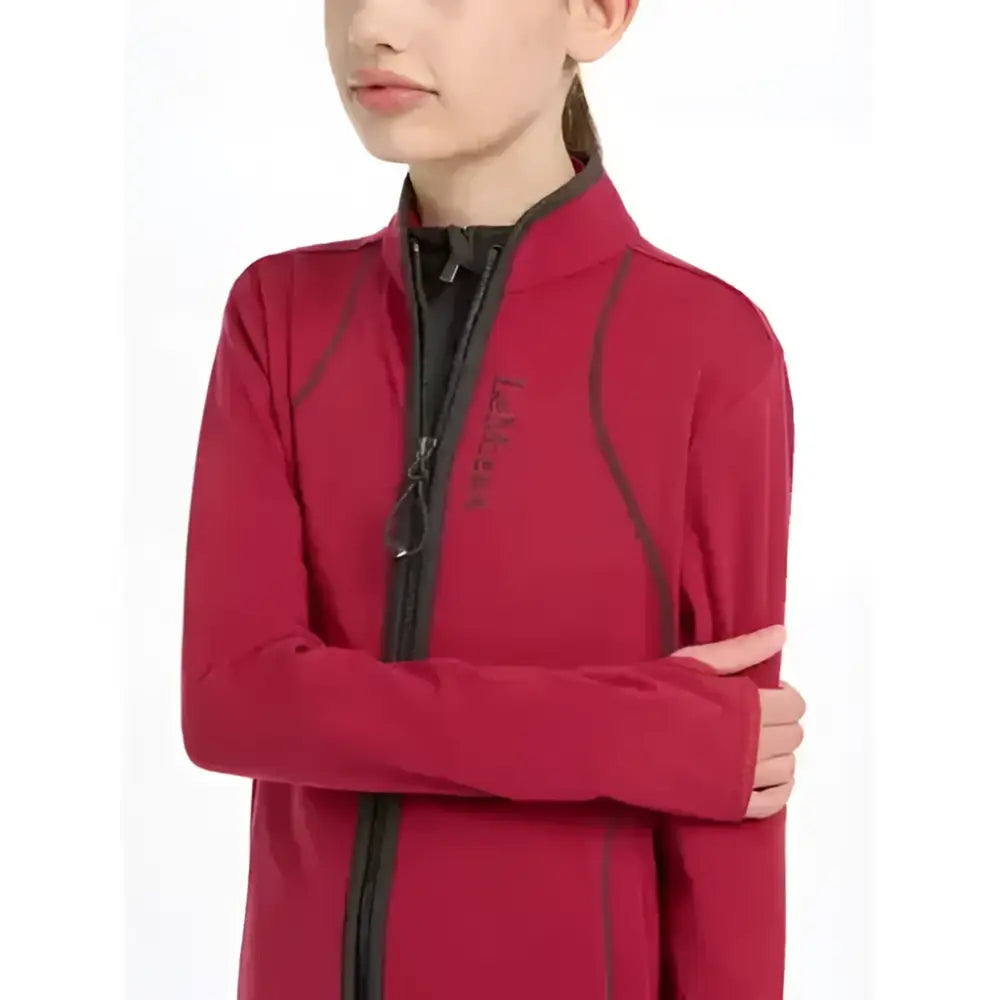 A vibrant red lemieux young rider long-sleeved fleece jacket with black zipper and dark seam piping ember color