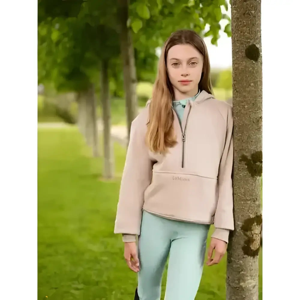 A soft beige lemieux young rider harriet pop zip-up hoodie with a subtle logo on the front pocket