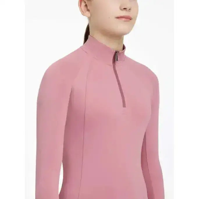 A soft pink lemieux young rider hope base layer peony with long sleeves high collar and zipper detail