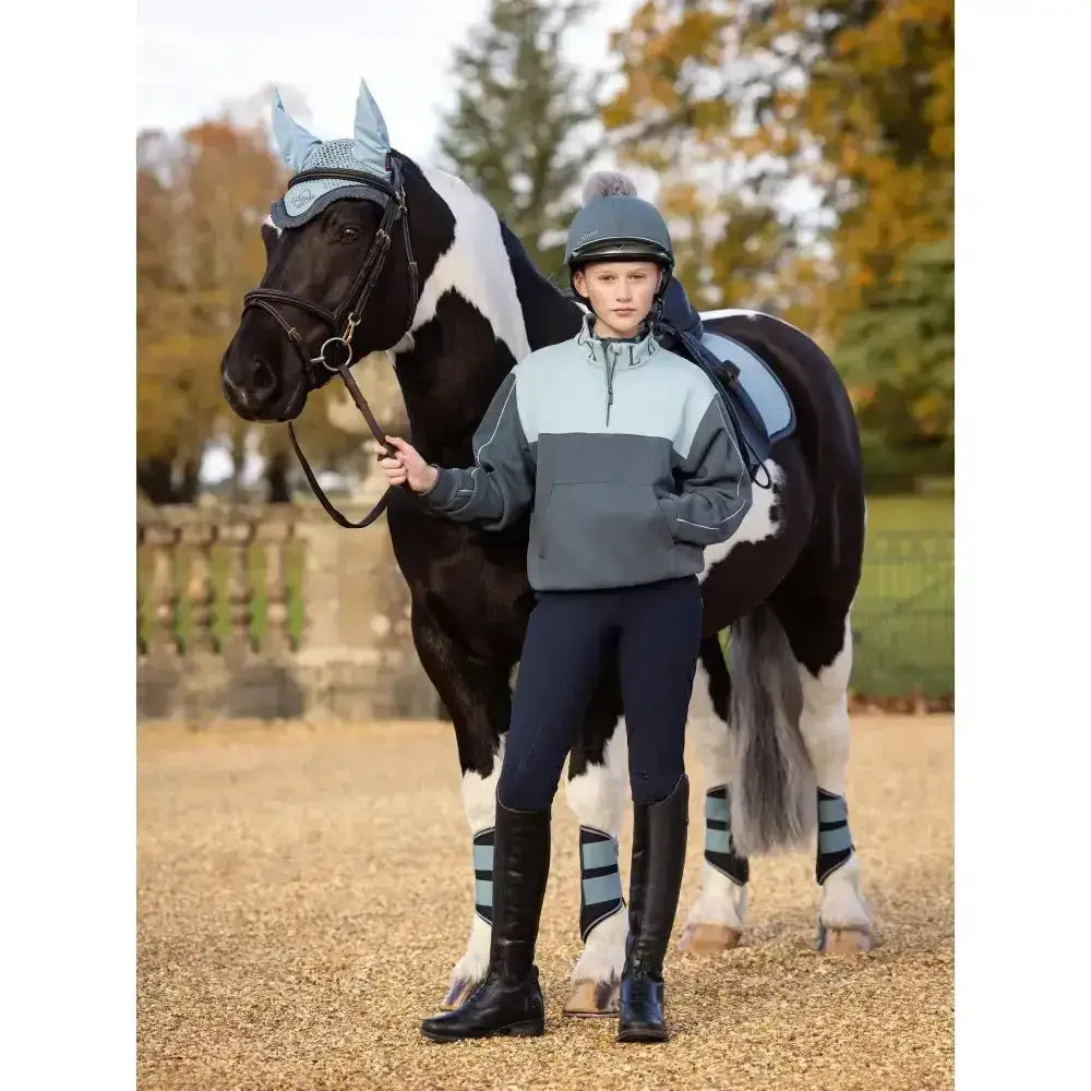 The lemieux young rider kate quarter zip sweat petrol in grey and light blue with reflective stripes on sleeves