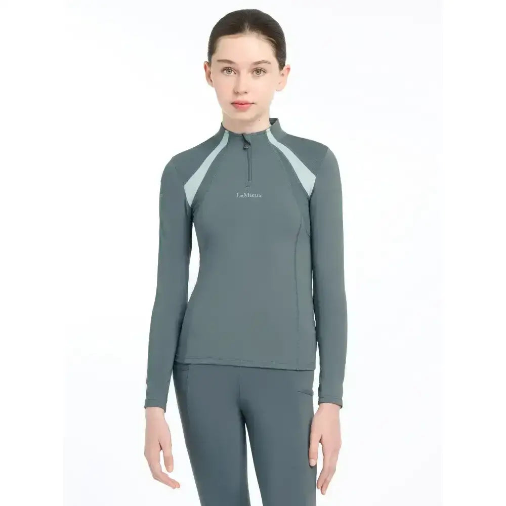 A sleek lemieux young rider mia mesh base layer long sleeve top in muted gray with light blue contrast panels