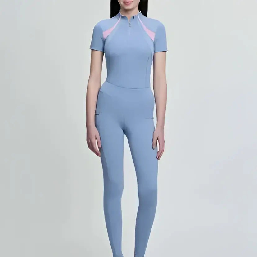 Light blue lemieux young rider orla pull athletic jumpsuit with pink accent panels on shoulders and neckline