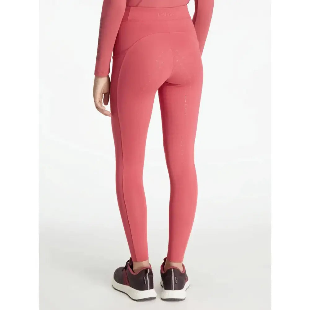 A pair of coral-pink lemieux young rider orla pull ons cranberry high-waisted stretchy leggings for riding